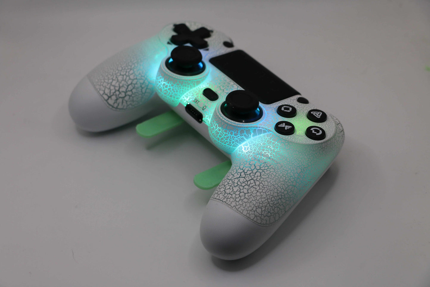Custom LED PS4 controller with glowing green and blue lights and textured grip surface